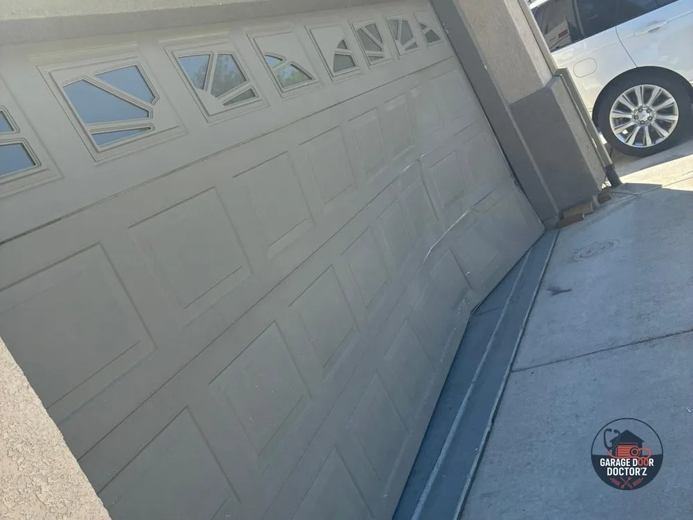 Before: garage door panels creased and buckled inward after an impact